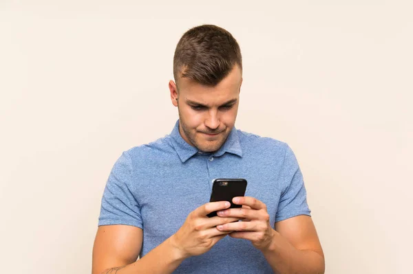 Ung blond man med mobiltelefon — Stockfoto