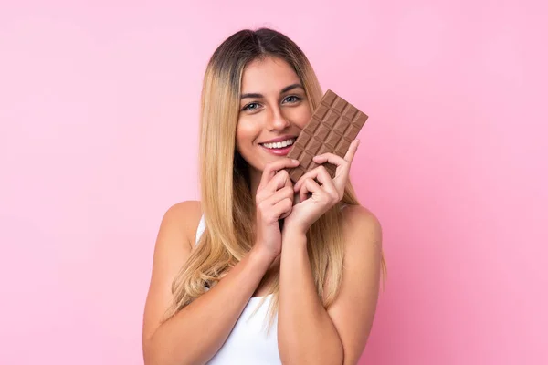 Mladá Uruguayská Žena Přes Izolované Růžové Pozadí Čokoládovou Tabletu Šťastný — Stock fotografie