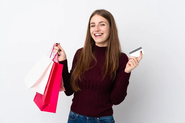 独立的白人背景的年轻女人拿着购物袋和信用卡 — 图库照片
