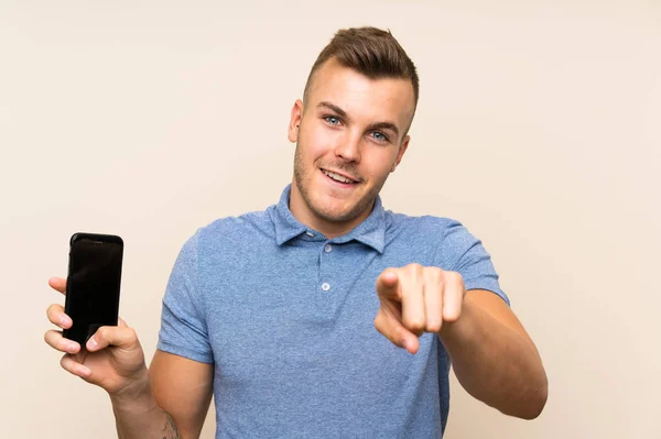 Jovem Loira Usando Telefone Celular Aponta Dedo Para Você Com — Fotografia de Stock