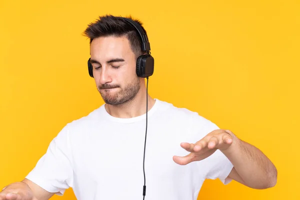 Młody Człowiek Żółtym Tle Słucha Muzyki Tańca — Zdjęcie stockowe