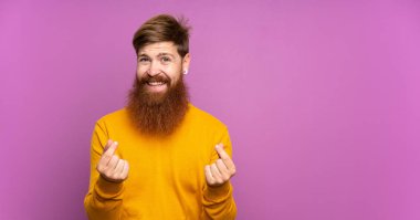 Uzun sakallı, soyutlanmış mor bir geçmişi olan kızıl saçlı adam para hareketi yapıyor.