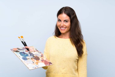 Soyutlanmış mavi arka planda genç bir sanatçı.