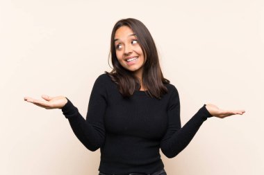 İzole edilmiş arka planda beyaz kazaklı esmer bir kadın iki eliyle kopyalama alanı tutuyor.