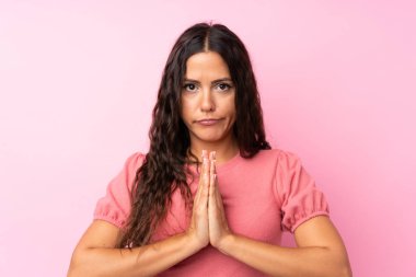 Izole pembe arka plan yalvaran üzerinde genç kadın