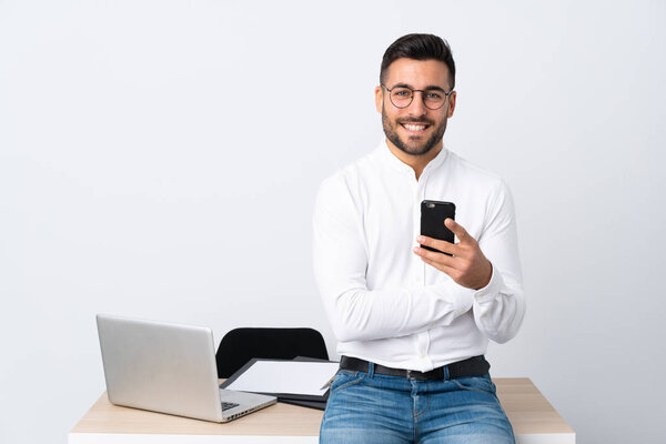 Young businessman holding a mobile phone laughing