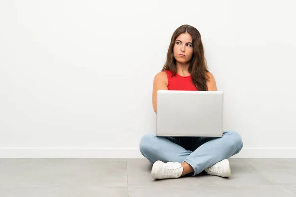 Junge Frau Mit Laptop Sitzt Auf Dem Boden Und Denkt — Stockfoto