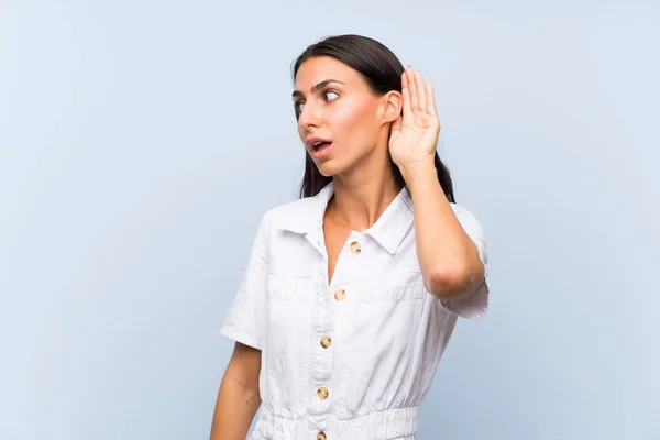 Mujer Joven Sobre Fondo Azul Aislado Escuchando Algo —  Fotos de Stock