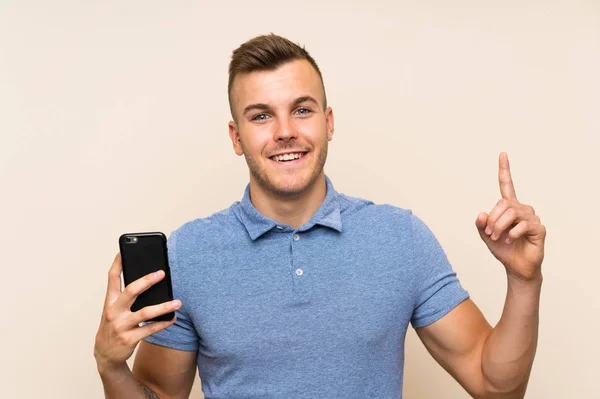 Młody Blondynka Człowiek Pomocą Telefon Komórkowy Wskazując Górę Świetny Pomysł — Zdjęcie stockowe
