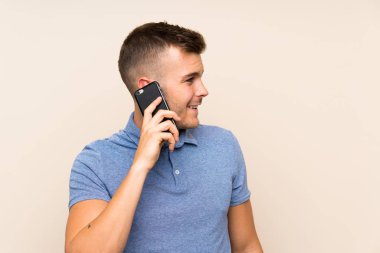 Genç sarışın adam cep telefonu kullanıyor.