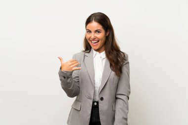 Soyutlanmış beyaz arka planda genç bir iş kadını telefon jesti yapıyor.