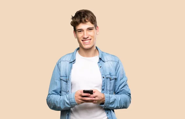 Beau Jeune Homme Envoyant Message Avec Mobile Sur Fond Isolé — Photo