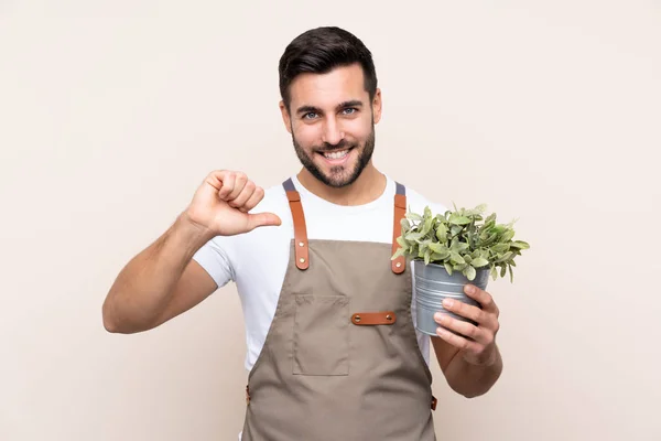 Jardinero Hombre Sosteniendo Una Planta Sobre Fondo Aislado Orgulloso Satisfecho —  Fotos de Stock