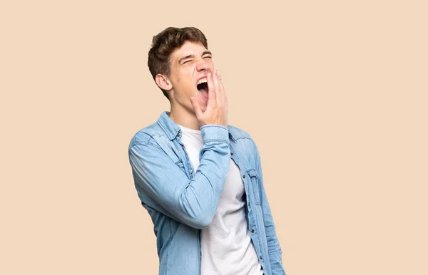 ハンサムな若いです男Yawningとカバー広いオープン口とともに手上の隔離された背景 — ストック写真