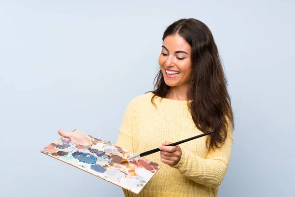 Izole mavi arka plan üzerinde genç sanatçı kadın — Stok fotoğraf