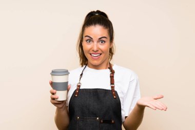 Genç bir çalışan elinde şok olmuş bir yüz ifadesiyle kahve tutuyor.