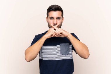 Sakallı, sakallı, genç ve yakışıklı bir adam. Sessizlik işareti gösteriyor.