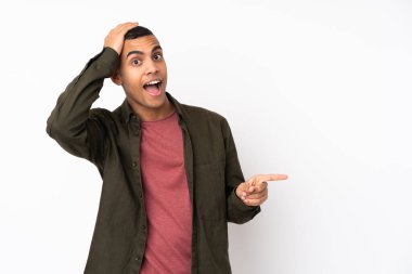 Genç Afro-Amerikan bir adam soyutlanmış beyaz arka planda şaşırmış ve işaret ediyor.