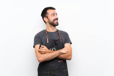 Önlüklü berber mutlu ve gülümsüyor.