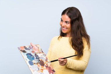 Izole mavi arka plan üzerinde genç sanatçı kadın