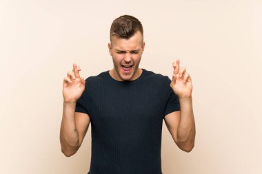 Genç, sarışın, izole edilmiş, parmakları çaprazlanmış bir adam.