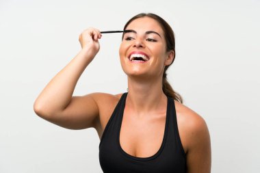 Kozmetik acele ile maskara uygulayarak izole beyaz arka plan üzerinde genç kadın