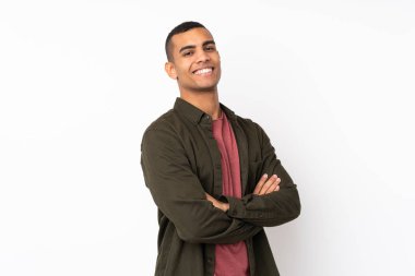 Afrika kökenli genç bir Amerikalı beyaz arka planda kolları bağlı ve ileriye bakıyor.