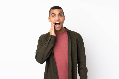 Genç Afrikalı Amerikalı, beyaz arka planda, şaşırmış ve şok olmuş bir yüz ifadesi var.