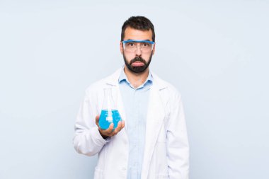 Hüzünlü ve depresif bir ifadeyle izole edilmiş arka plan üzerinde genç bilimsel deney şişesi.