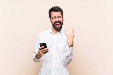 Sakallı genç adam hareketli bir kaya hareketi yapıyor.