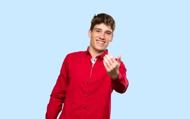 Yakışıklı genç adam soyutlanmış mavi arka planda kalmaya davet ediyor.