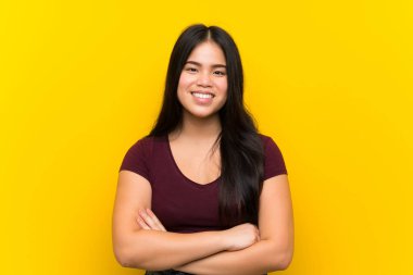 Izole sarı arka plan üzerinde genç genç Asyalı kız gülüyor