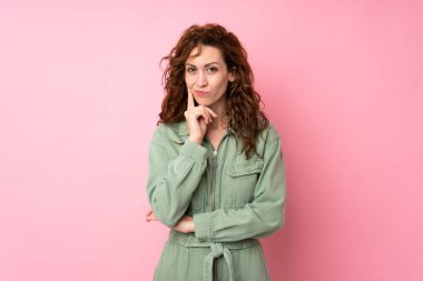 Soyutlanmış pembe arka planda genç ve güzel bir kadın.