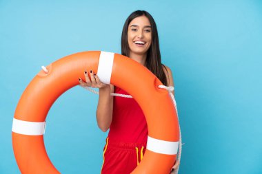 Cankurtaran kadın, izole edilmiş mavi arka plan, cankurtaran ekipmanları ve mutlu bir ifadeyle.