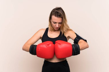 Sarışın sporcu kadın, izole edilmiş arka planda boks eldivenli.