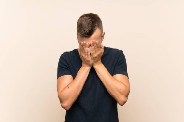 Yorgun ve hasta ifade ile izole arka plan üzerinde Genç yakışıklı sarışın adam