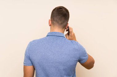 Genç sarışın adam cep telefonu kullanıyor.