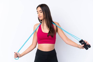 Genç, esmer, soyutlanmış, atlama halatıyla beyaz arka planda bir kadın.