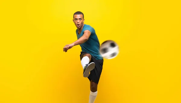 Afro amerykański piłkarz człowiek na odizolowanym żółtym tle — Zdjęcie stockowe