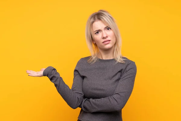 Giovane Donna Bionda Sfondo Giallo Isolato Infelice Non Capire Qualcosa — Foto Stock