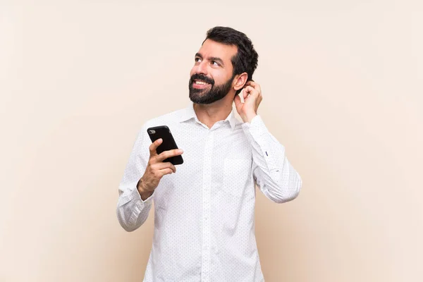 Junger Mann Mit Bart Hält Ein Handy Der Hand Und — Stockfoto