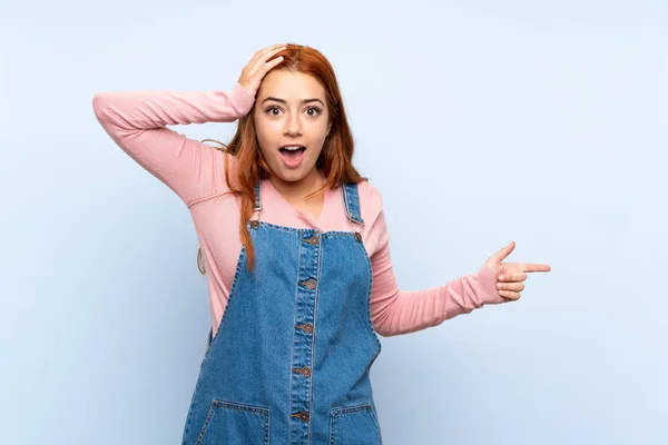 Adolescente Ruiva Menina Com Macacão Sobre Isolado Fundo Azul Surpreso — Fotografia de Stock