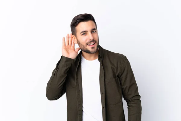 Jovem Homem Bonito Com Barba Sobre Fundo Branco Isolado Ouvindo — Fotografia de Stock