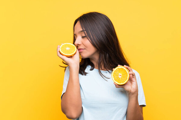 Young brunette girl holding an orange