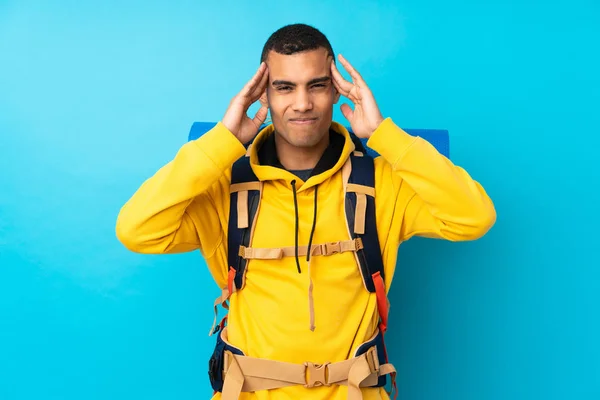 Fiatal Hegymászó Férfi Egy Nagy Hátizsákkal Elszigetelt Kék Háttér Boldogtalan — Stock Fotó