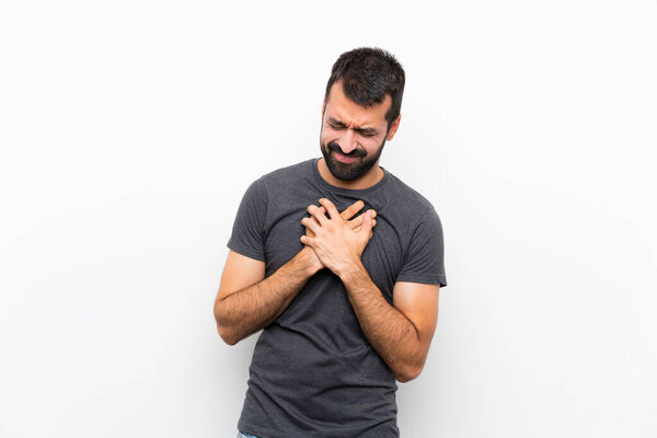 Young handsome man over isolated white background having a pain in the heart