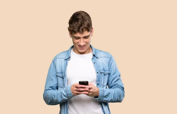 Beau Jeune Homme Envoyant Message Avec Mobile Sur Fond Isolé — Photo