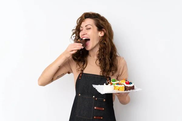 Młoda Ładna Kobieta Odosobnionym Tle Trzymając Mini Ciasta Jedząc — Zdjęcie stockowe