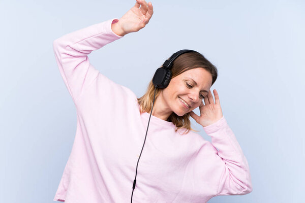 Wwoman listening music over isolated blue wall