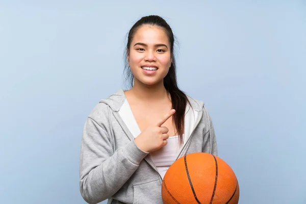 Jong Aziatisch Meisje Spelen Basketbal Geïsoleerde Achtergrond Wijzend Naar Kant — Stockfoto